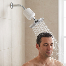 Load image into Gallery viewer, KDF shower filter angled downward with water directed onto the top of a man's head
