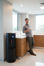 Load image into Gallery viewer, Man holding water glass, black Clover D7A in corner next to cabinets
